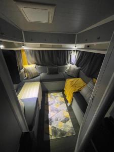 Cette petite chambre comprend un lit et une couverture jaune. dans l'établissement Surfer Mammut, à Ipswich