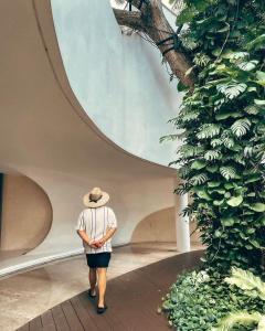 eine Frau mit Hut, die durch ein Gebäude geht in der Unterkunft Tambuli Seaside Residences Buyong Road Maribago Lapu Lapu City in Cogon
