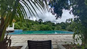 a swimming pool in the middle of a yard at Gavadana Resort Coorg in Madikeri