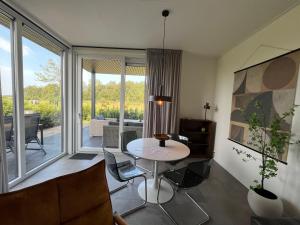 a living room with a table and chairs and a large window at Sunset Lodge in Lutten