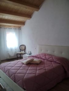 a bedroom with a large bed with a purple comforter at La casa di Alice in Venice