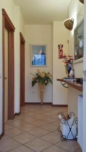 einen Flur mit einer Blumenvase in einem Zimmer in der Unterkunft La Fonte Guest House in Sirolo