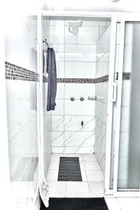 a white bathroom with a shower with a towel at The O Apartment in Ongata Rongai  +14 photos