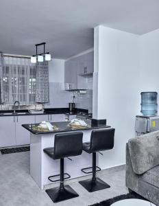 a kitchen with a counter and two bar stools at The O Apartment in Ongata Rongai 