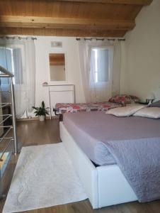 a bedroom with a large bed and two windows at La casa di Alice in Venice