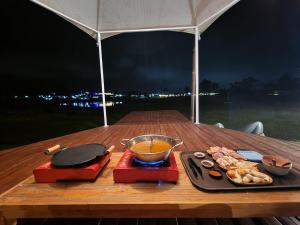a table with a bowl of soup and a plate of food at Seribu Pulau Pangalengan in Citere