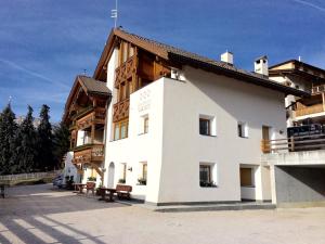 een groot wit gebouw met een dak bij Residence Vajolet San Cassiano in San Cassiano