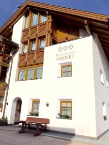 a building with a bench in front of it at Residence Vajolet San Cassiano in San Cassiano