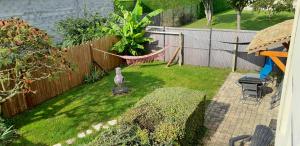 ein Hinterhof mit Zaun und ein Hof mit Hängematte in der Unterkunft Ferme de Beaulieu, appartement avec jardin privatif in Neauphlette