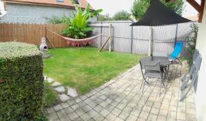 eine Terrasse mit einer Hängematte und einem Stuhl in einem Hof in der Unterkunft Ferme de Beaulieu, appartement avec jardin privatif in Neauphlette