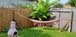 eine Hängematte in einem Garten neben einem Zaun in der Unterkunft Ferme de Beaulieu, appartement avec jardin privatif in Neauphlette