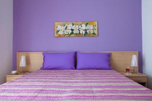 a purple bedroom with a bed with purple pillows at Vado Al Massimo in Palermo
