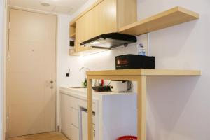 eine kleine Küche mit einem Tisch und einer Theke in der Unterkunft Modern Studio Room at Tokyo Riverside PIK 2 Apartment By Travelio in Rawalembang