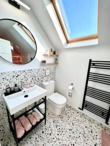 a bathroom with a toilet and a sink and a mirror at Thistledown Lodge in Fethard on Sea +67 photos