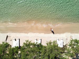 a person standing on a beach near the ocean at Sani Club in Sani Beach