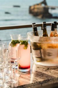 a table with wine bottles and glasses on it at Hôtel de La Plage in Biarritz