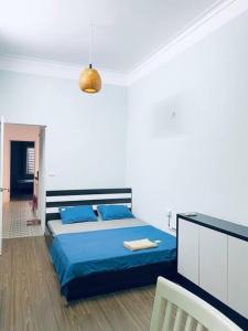 a bedroom with a bed with a blue comforter at Homestay May's house Lo Duc in Hanoi