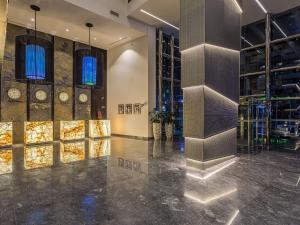 a lobby with a wall of clocks and mirrors at The First Collection Dubai Marina in Dubai