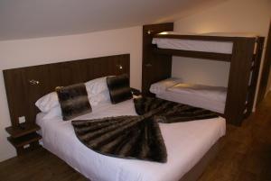 a bedroom with two bunk beds with towels on them at Hotel L’Ermita B&B in Canillo