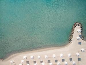 an overhead view of a beach with white umbrellas at Sani Club in Sani Beach