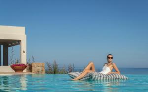 a woman sitting on an inflatable ball in a swimming pool at Sani Club in Sani Beach