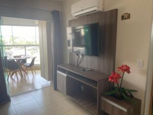 カルダス・ノバスにあるApartamento confortável em caldas novas com espaço aquático, 6 piscinas , 3 hidromassagem , Bar e Restaurante , Sauna , espaço kidsのテレビ付きの部屋、リビングルーム(テーブル付)