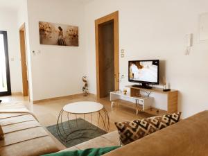 Una sala de estar con un sofá y un televisor en Chiraz Magesty loft, en Sidi Daoud