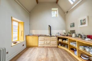 Una gran cocina con gabinetes de madera en una habitación. en Seventeenth century luxury pad near Glastonbury, en Pilton