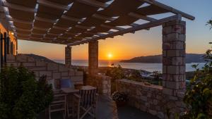 a patio with a sunset in the background at Themonia Studios Kimolos in Kimolos