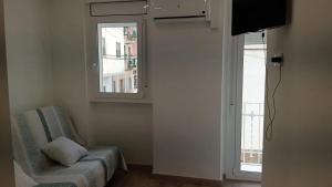 a living room with a chair and a window at Charming apartment in La Ràpita, 30 m² with balcony in Sant Carles de la Ràpita