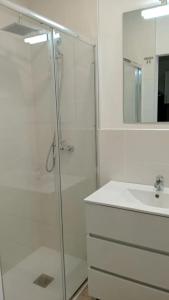 a white bathroom with a shower and a sink at Charming apartment in La Ràpita, 30 m² with balcony in Sant Carles de la Ràpita +11 photos