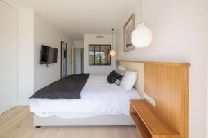 een slaapkamer met een bed en een tv aan de muur bij Villa Cordouan avec piscine en bord de mer in Royan +17 foto's