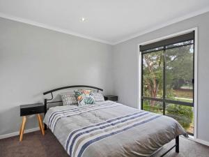 Un dormitorio con una cama y una ventana grande. en Chez Reeve, en Lock Sport