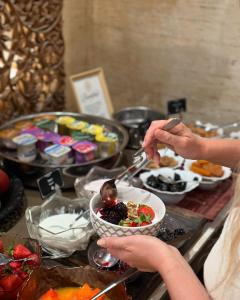 a person holding a spoon over a bowl of food at Royal Garden Villas, Luxury Hotel in Adeje