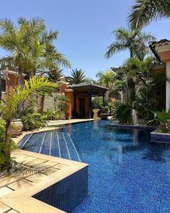 a swimming pool in a resort with palm trees at Royal Garden Villas, Luxury Hotel in Adeje