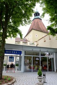 ein Gebäude mit einem Uhrturm darüber in der Unterkunft Klassik Hotel am Tor in Weiden