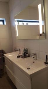 a bathroom with a white sink and a mirror at Rom til leie - rolig villastrøk nært flyplassen in Tromsø