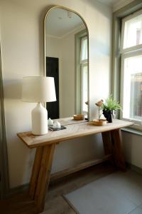 a dressing table with a mirror and a lamp on it at Vaksali Apartment, kaks minutit Ugalast in Viljandi
