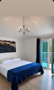a bedroom with a bed with a blue blanket at Villa Sandra in Gruda