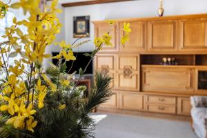 a vase filled with yellow flowers in a living room at Ferienwohnung Regina in Furtwangen
