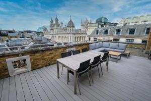 a table and chairs on a roof with a view of a city at Chancery Quarters - 124 Chancery Lane in London