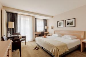 a hotel room with a large bed and a desk at Hotel Aazaert by WP Hotels in Blankenberge +34 photos
