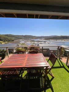 a wooden table and chairs on a deck with a view at Aquila Chalet Phantom Views in Knysna