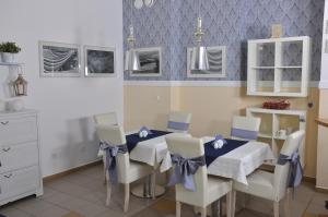 a dining room with a blue table and white chairs at Villa Krystyna in Dźwirzyno