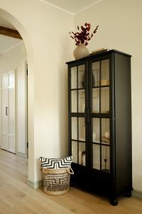 a black cabinet with a vase on top in a room at Vaksali Apartment, kaks minutit Ugalast in Viljandi +10 photos