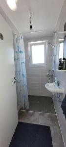 a bathroom with a sink and a shower curtain at Schöne Drei Zimmerwohnung in Ebersbach an der Fils +13 photos