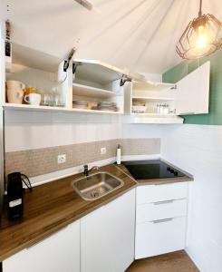 a kitchen with white cabinets and a sink at Estudio MELMAR en Playamar in Torremolinos