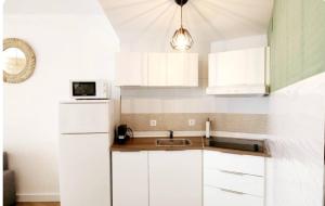 a white kitchen with a sink and a microwave at Estudio MELMAR en Playamar in Torremolinos