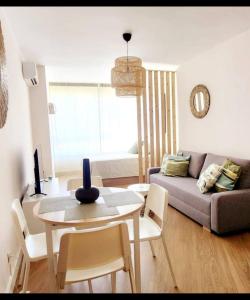 a living room with a table and a couch at Estudio MELMAR en Playamar in Torremolinos +23 photos