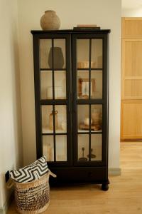a black cabinet with glass doors in a room at Vaksali Apartment, kaks minutit Ugalast in Viljandi